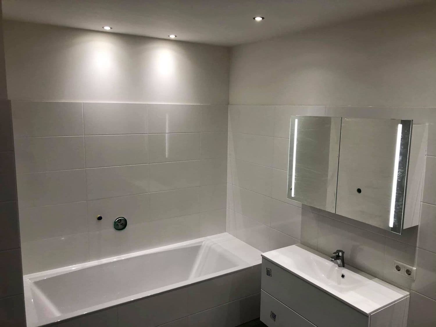 Frisch saniertes Bad mit Badewanne und LED-Spiegelschrank